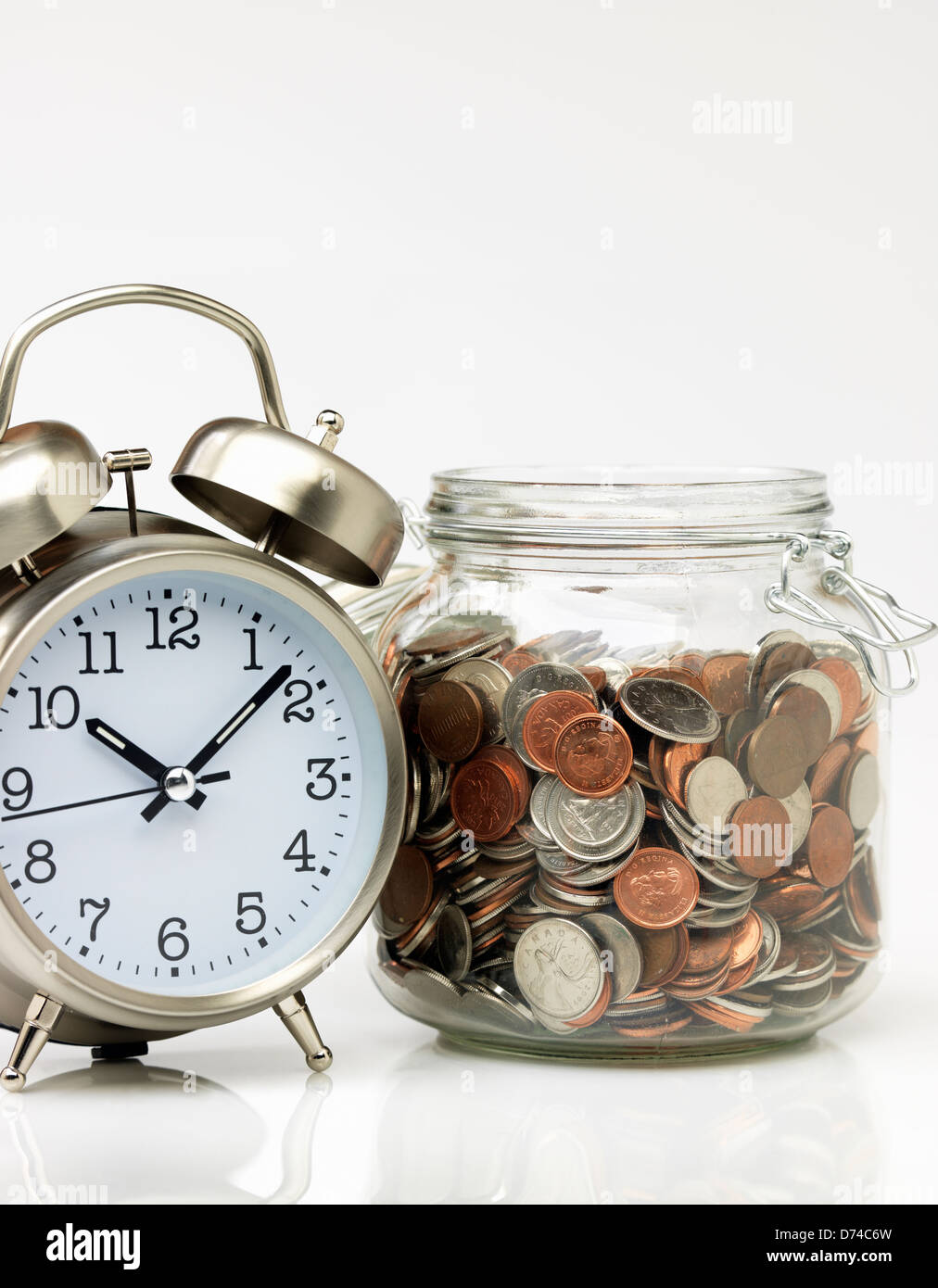 Il tempo è denaro, orologio e il vaso pieno di denaro Foto Stock