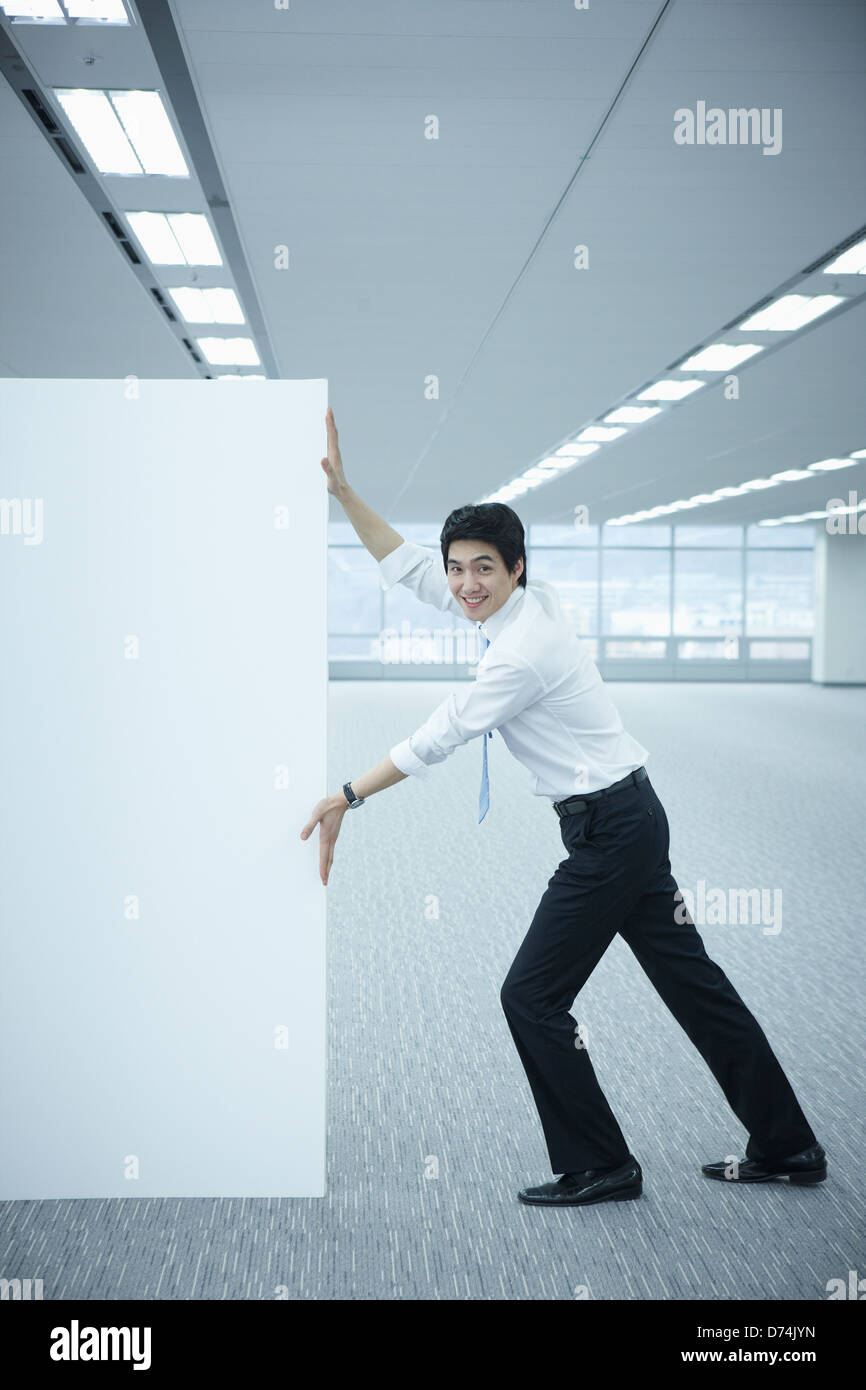 Un imprenditore spingendo una lavagna vuota Foto Stock