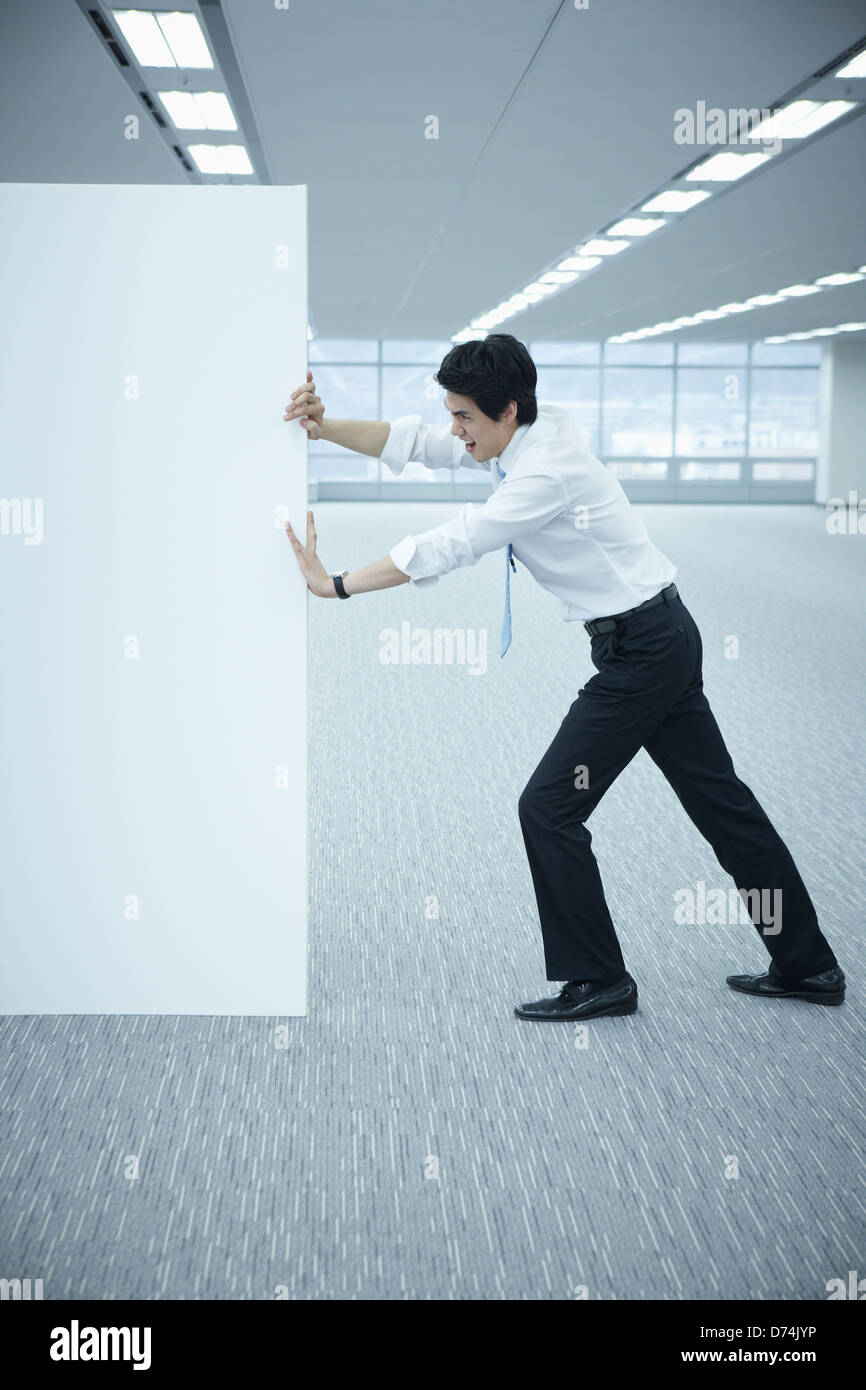 Un imprenditore spingendo una lavagna vuota Foto Stock