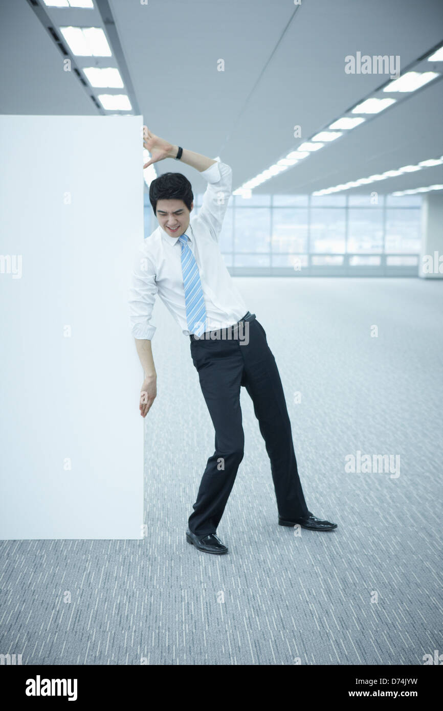 Un imprenditore spingendo una lavagna vuota Foto Stock