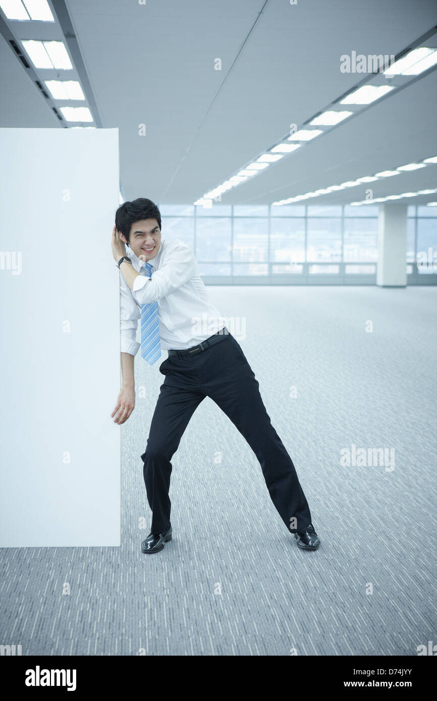 Un imprenditore spingendo una lavagna vuota Foto Stock