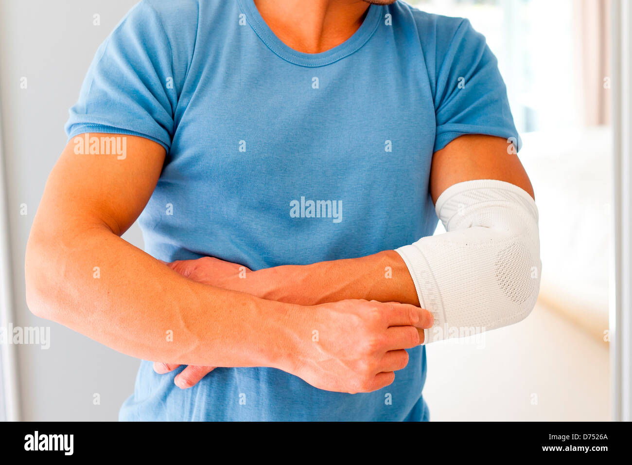 Uomo che indossa un supporto a gomito. Foto Stock