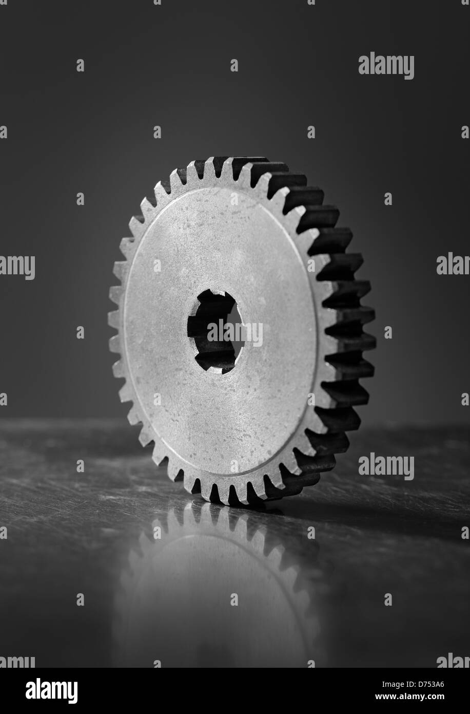 Immagine in bianco e nero di un vecchio cog metallica dentata sul graffiato sfondo metallico. Breve di profondità di campo. Foto Stock