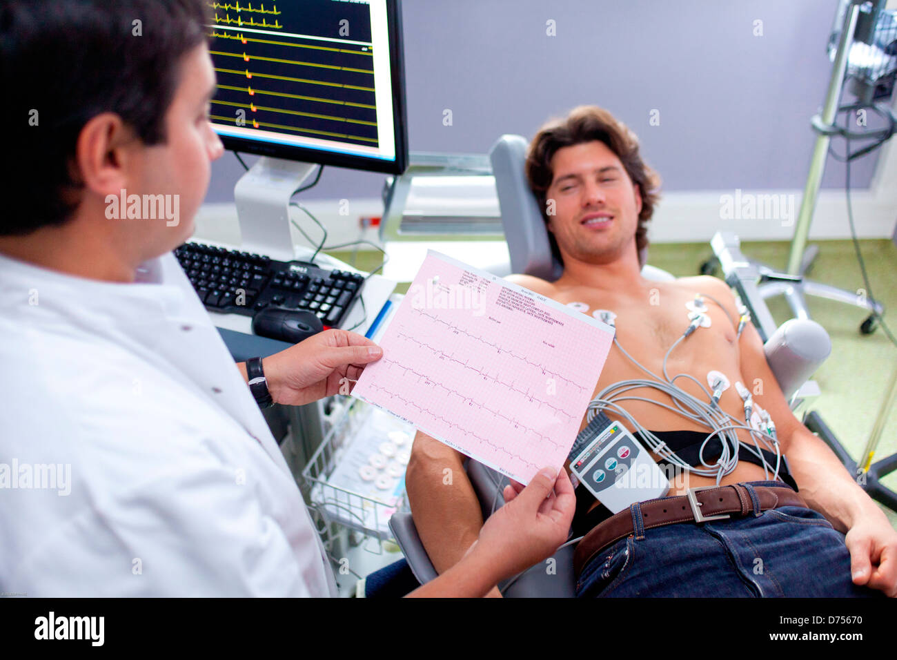 Cuore portatile monitor. Uomo che indossa un elettrocardiografo portatile appeso su un laccetto da collo. Ospedale di Limoges, Francia. Foto Stock