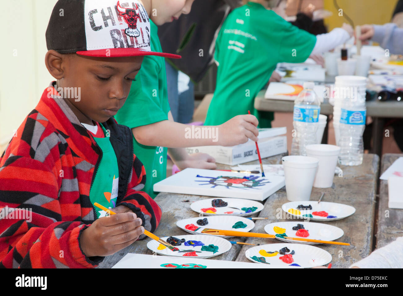 I bambini lavorano su progetti di artigianato mentre i loro genitori volontari per la comunità di progetti di miglioramento al Motor City batterico Busters. Foto Stock
