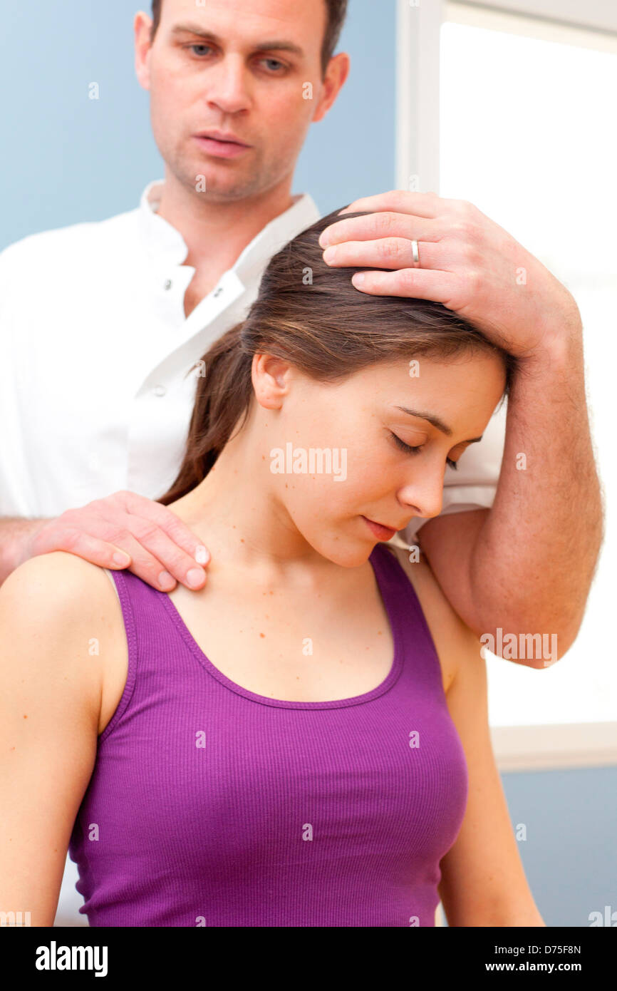 Osteopatia strutturale di sessione in una donna che soffriva di dolori al collo. Foto Stock