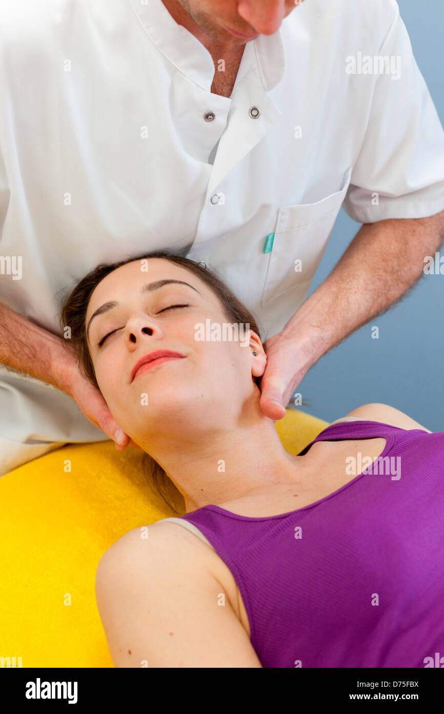 Osteopatia strutturale di sessione in una donna che soffriva di dolori al collo. Foto Stock