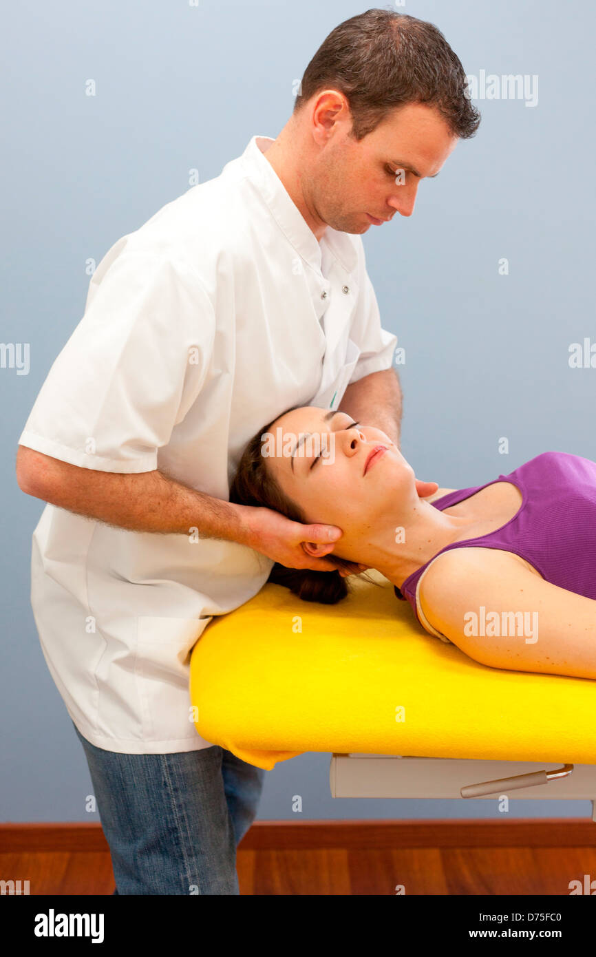 Osteopatia strutturale di sessione in una donna che soffriva di dolori al collo. Foto Stock