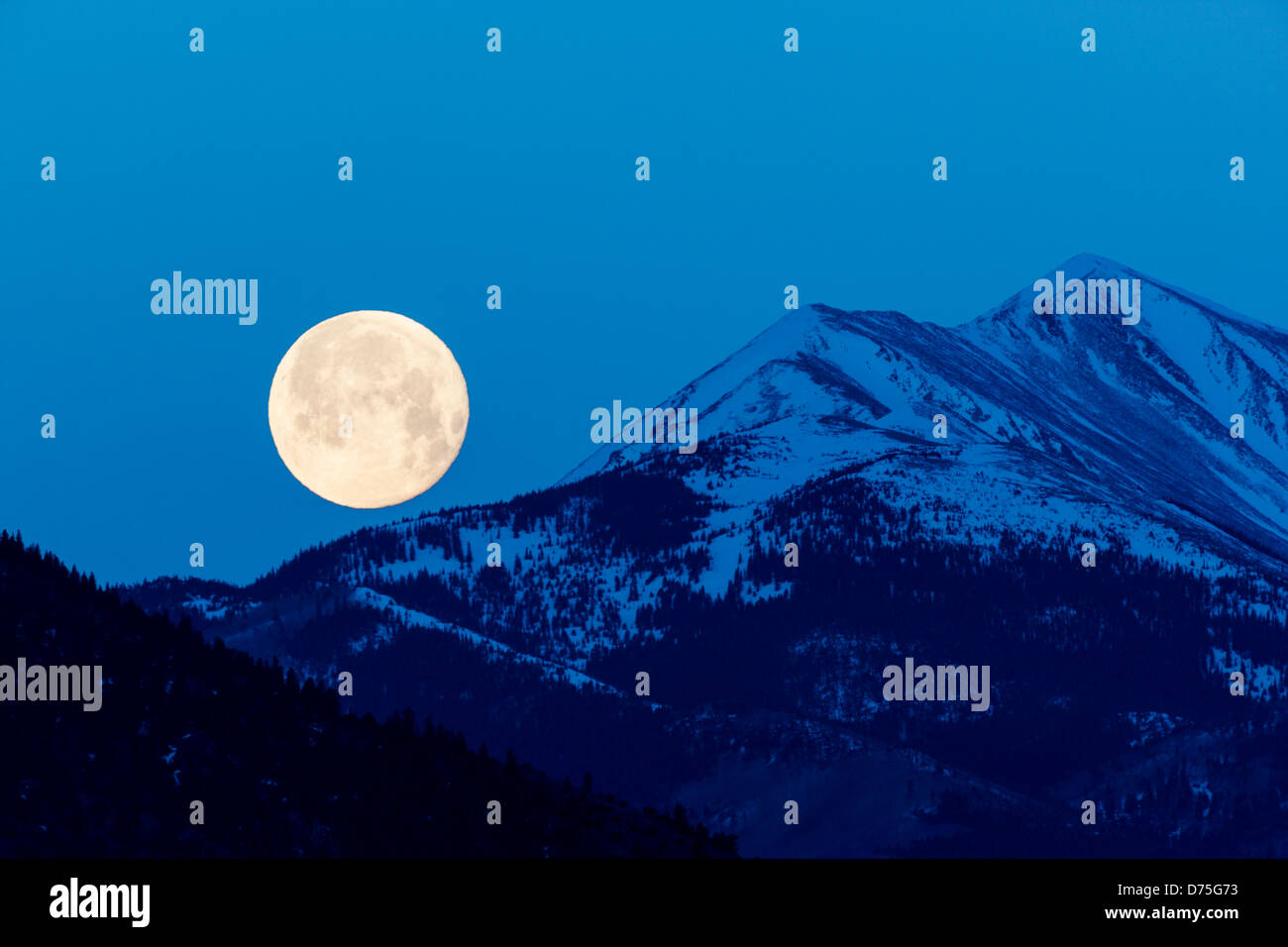 Luna piena impostazione su montagne rocciose, Salida, Colorado, STATI UNITI D'AMERICA Foto Stock