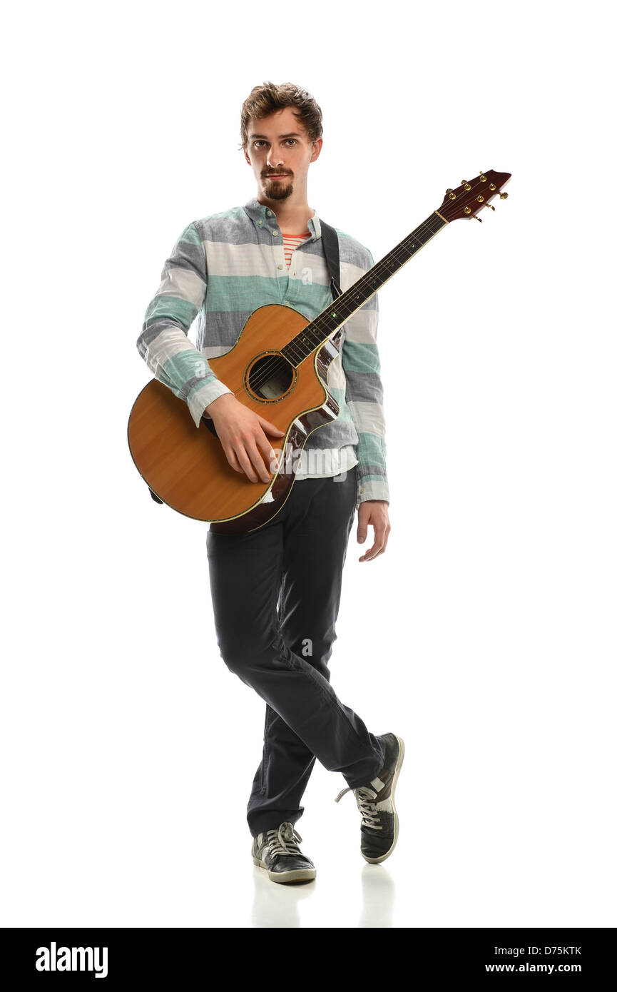 Giovane uomo con la chitarra acustica in piedi su sfondo bianco Foto Stock