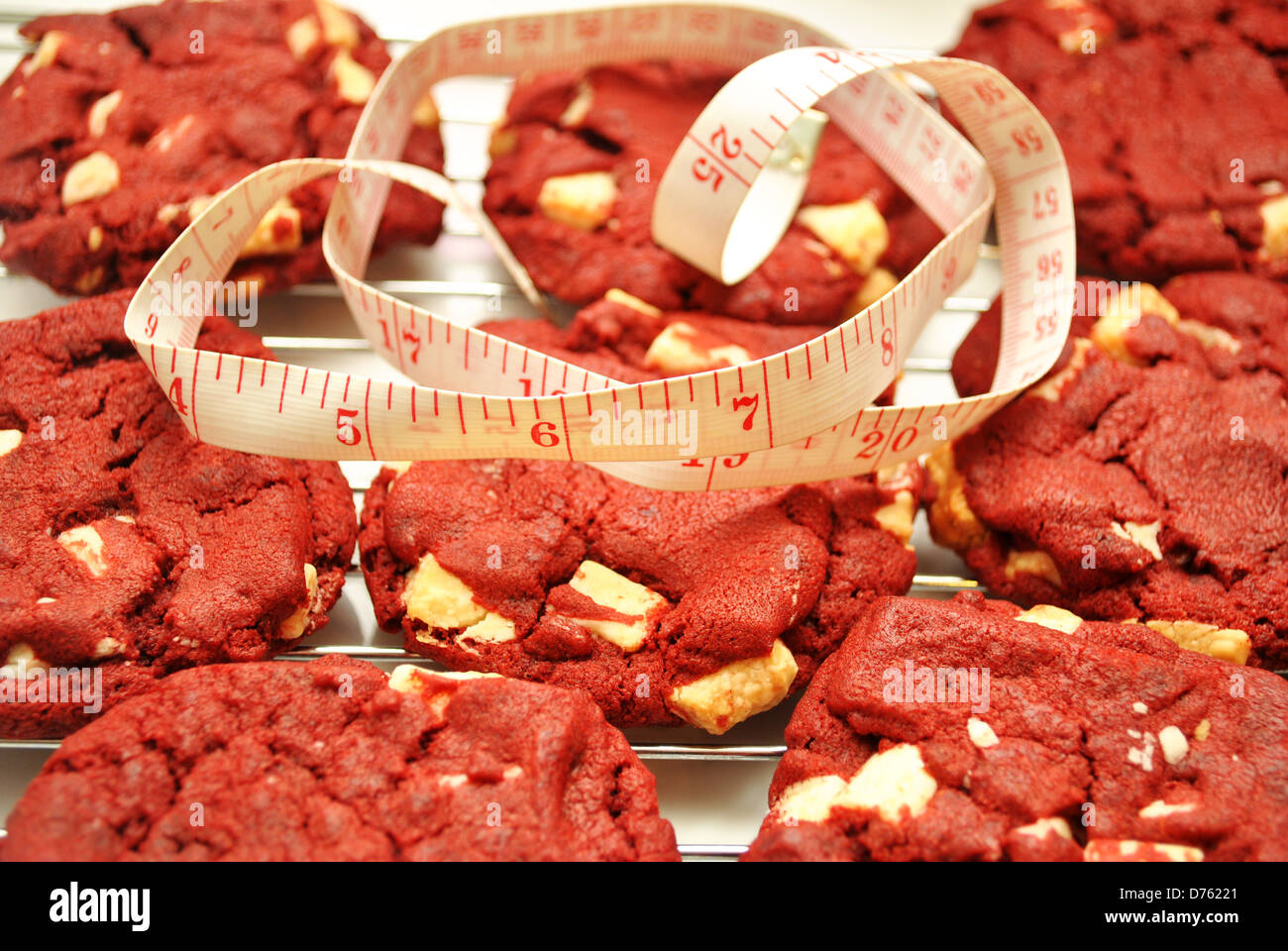 Velluto rosso i cookie con un nastro di misurazione Foto Stock