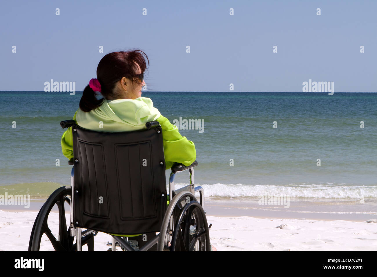 Portatori di handicap donna siede disabili in sedia a rotelle in spiaggia. Foto Stock