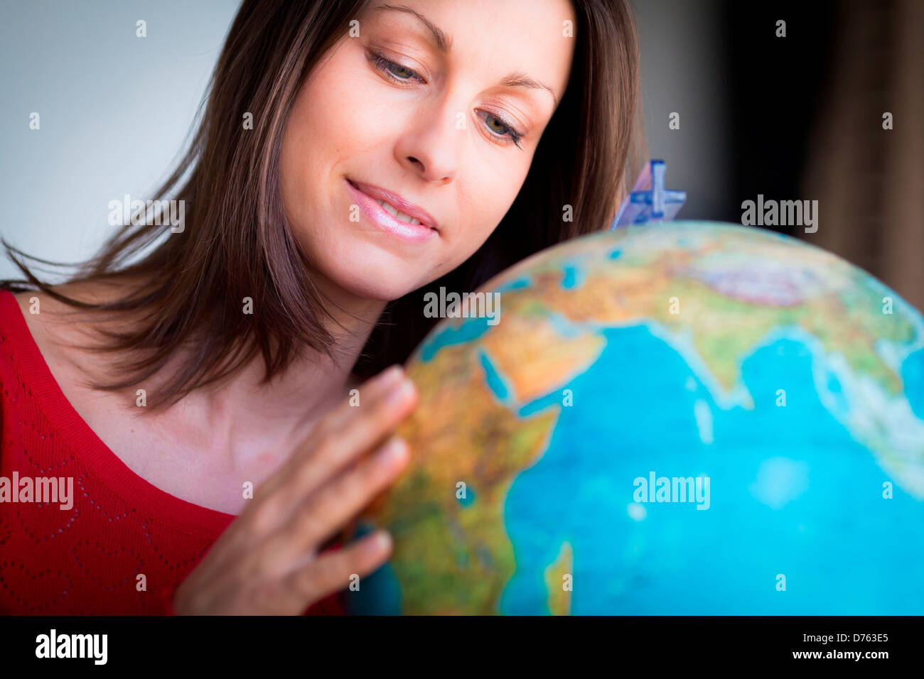 Donna che guarda la mappa del mondo Foto Stock