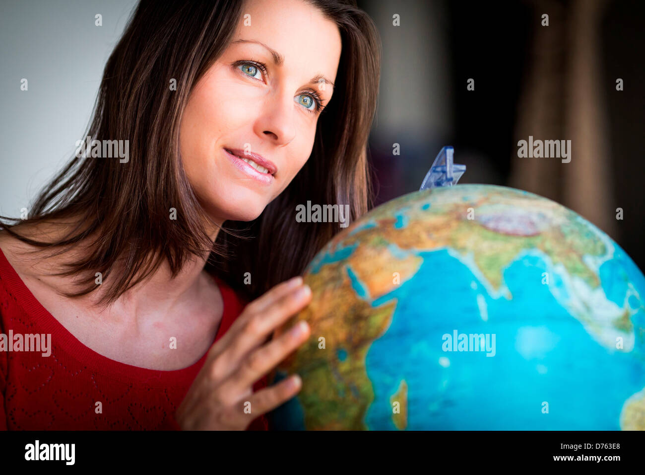 Donna che guarda la mappa del mondo Foto Stock