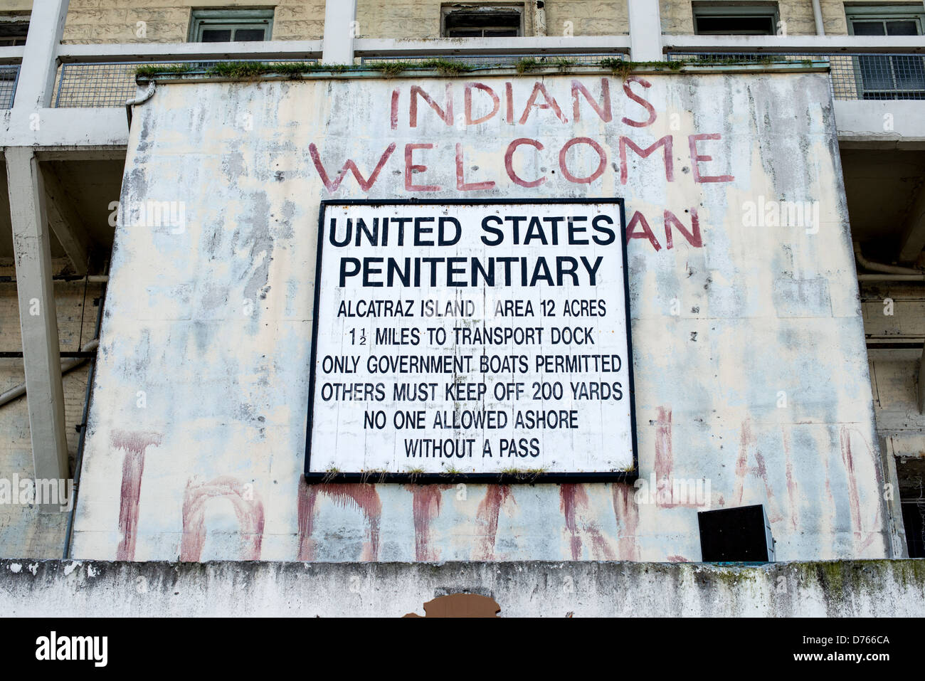 Isola di Alcatraz Indians Welcome Graffiti San Francisco | SAN FRANCISCO, California — Un cartello di avvertimento federale consumato e un graffito rosso con la scritta "Indians Welcome" segnano l'ingresso dell'isola di Alcatraz nella baia di San Francisco. Le parole dipinte sopra il cartello ufficiale del penitenziario risalgono all'occupazione di Alcatraz da parte del gruppo Indians of All Tribes dal 1969 al 1971. La protesta storica vide attivisti nativi americani occupare l'ex prigione federale per 19 mesi, rivendicando l'isola in base a un trattato del 1868 che permetteva ai nativi americani di rivendicare terre federali inutilizzate. L'occupazione divenne un punto di svolta Foto Stock