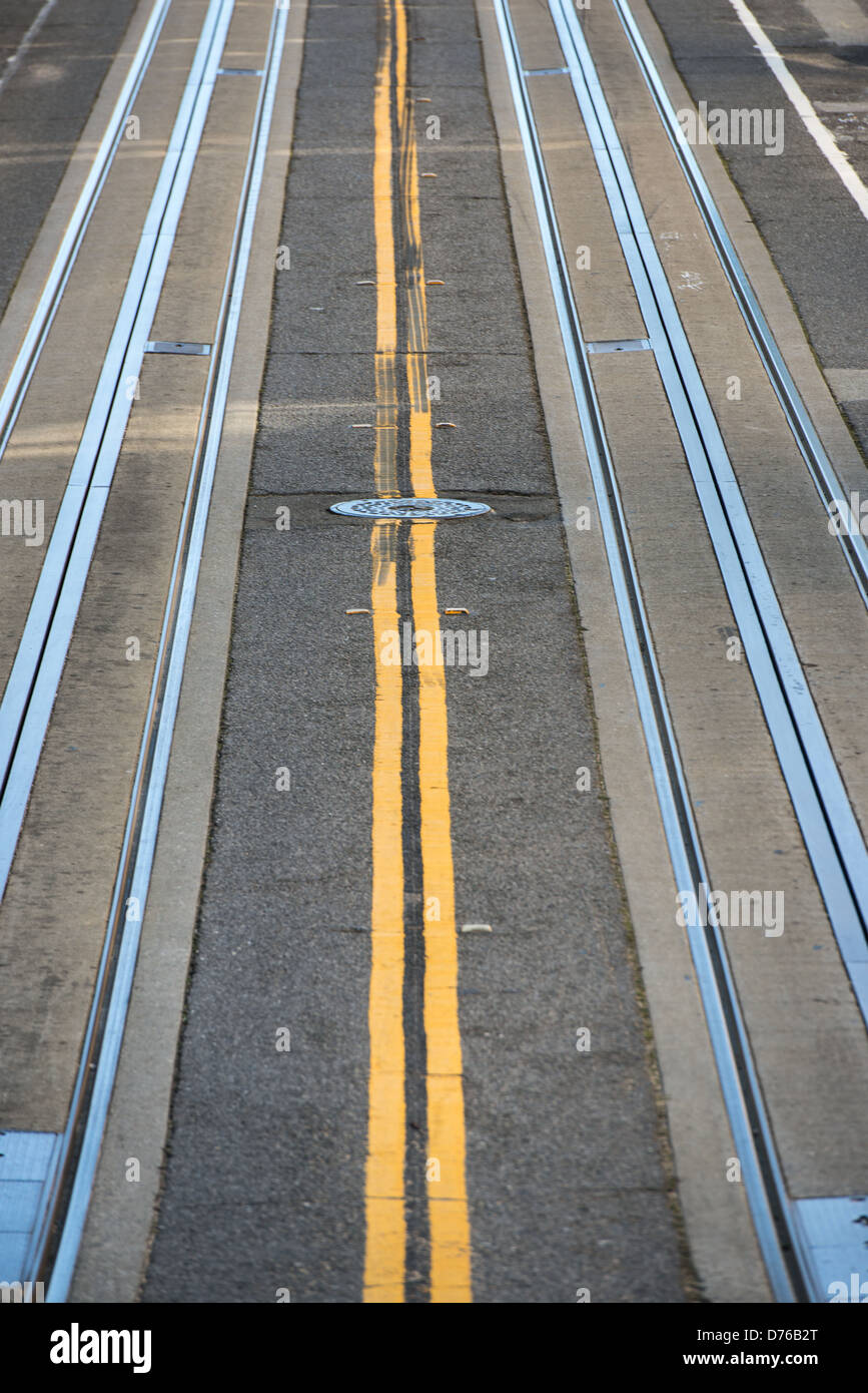 Piste per funivie San Francisco California // SAN FRANCISCO, California - le piste per funivie sono incorporate nel marciapiede di una delle strade tipicamente ripide di San Francisco. La funivia della città, che ha iniziato le operazioni nel 1873, utilizza una rete di cavi sotterranei per tirare le auto su e giù per il terreno impegnativo della città. Le funivie di San Francisco sono tra i pochi sistemi di funivie a comando manuale ancora in uso in tutto il mondo e sono state designate come National Historic Landmark nel 1964. La ripida topografia che ha reso necessario questo sistema di trasporto è una caratteristica distintiva di San Francesco Foto Stock Piste per funivie San Francisco California // SAN FRANCISCO, California - le piste per funivie sono incorporate nel marciapiede di una delle strade tipicamente ripide di San Francisco. La funivia della città, che ha iniziato le operazioni nel 1873, utilizza una rete di cavi sotterranei per tirare le auto su e giù per il terreno impegnativo della città. Le funivie di San Francisco sono tra i pochi sistemi di funivie a comando manuale ancora in uso in tutto il mondo e sono state designate come National Historic Landmark nel 1964. La ripida topografia che ha reso necessario questo sistema di trasporto è una caratteristica distintiva di San Francesco Foto Stock
