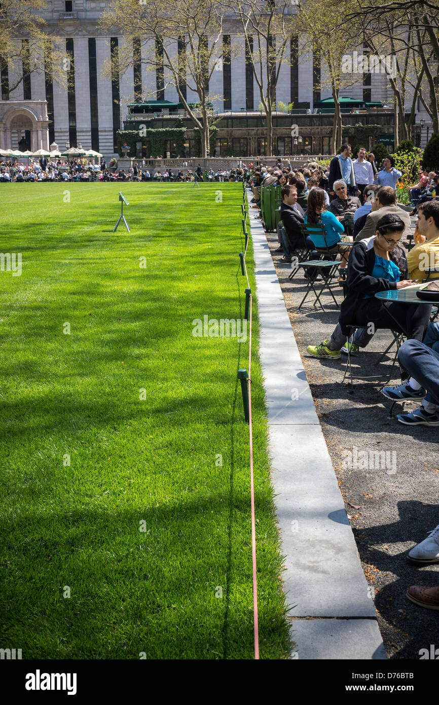 I visitatori al Bryant Park di New York la linea fino al prato chiuso durante le loro ore pranzo Foto Stock