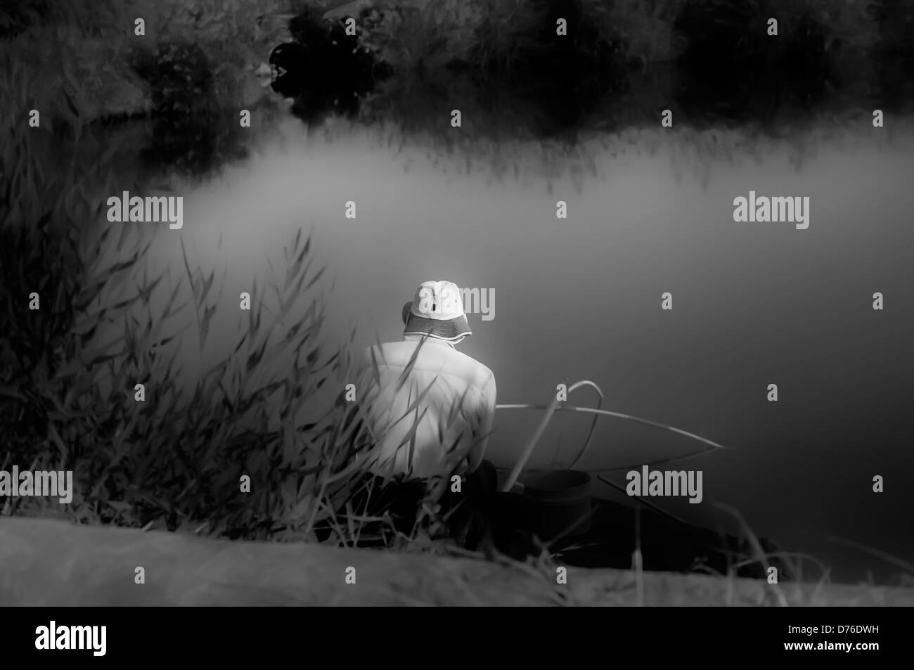 Uomo di pesca in lago con torna alla telecamera in bianco e nero Foto Stock