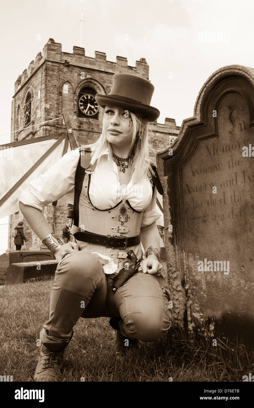 Whitby Goth weekend.Goth in posa vicino a headstone, St Mary's Church Whitby, North Yorkshire, Inghilterra, Regno Unito Foto Stock