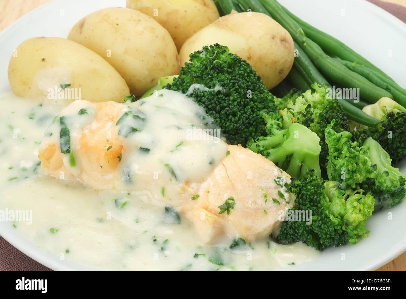 Filetto di salmone alla griglia con patate di primizia, broccoli, fagioli verdi e cremosa salsa di crescione Foto Stock
