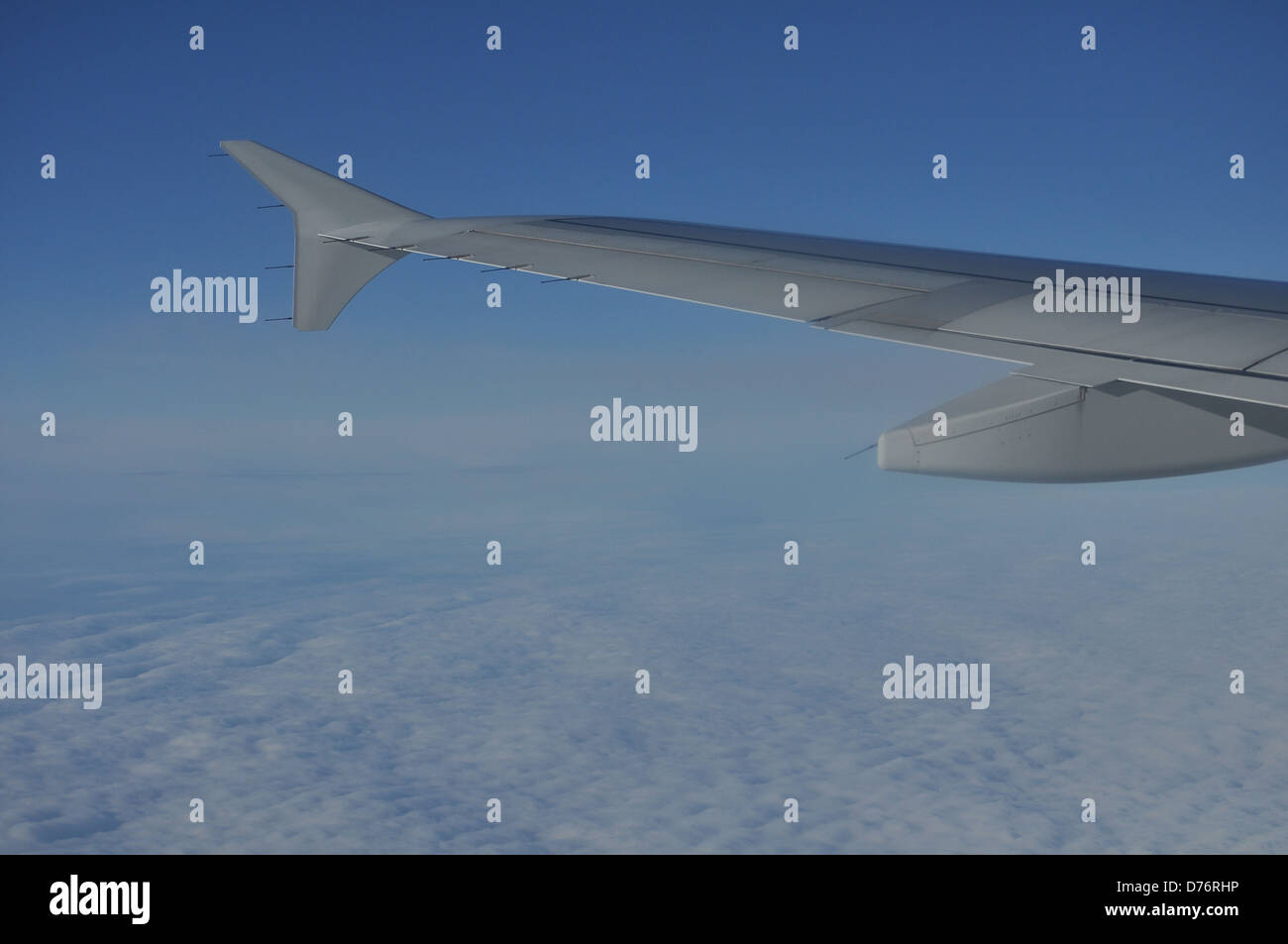 Un brillante ala di un aereo sopra le nuvole nel cielo Foto Stock