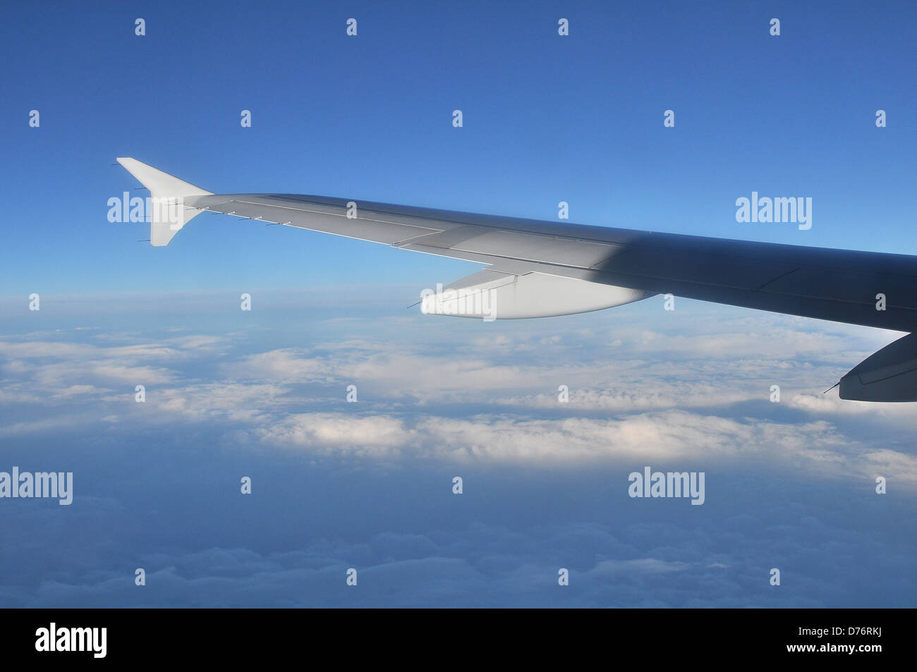 Un brillante ala di un aereo sopra le nuvole nel cielo Foto Stock