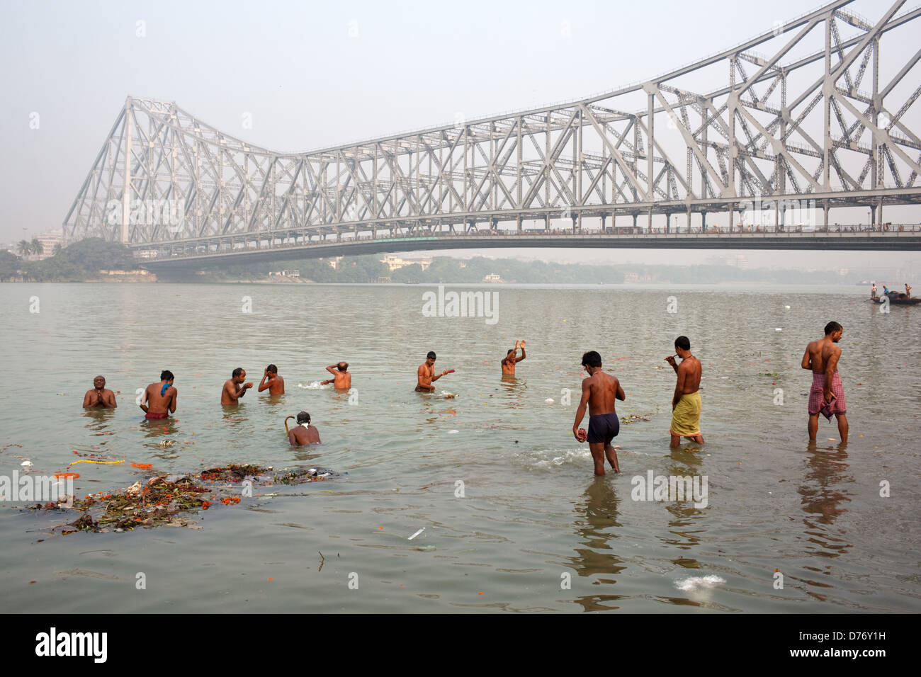 La gente a prendere bagno mattutino nel Fiume Hooghly vicino a quella di Howrah Bridge (Rabindra Setu) in Kolkata, India. Foto Stock