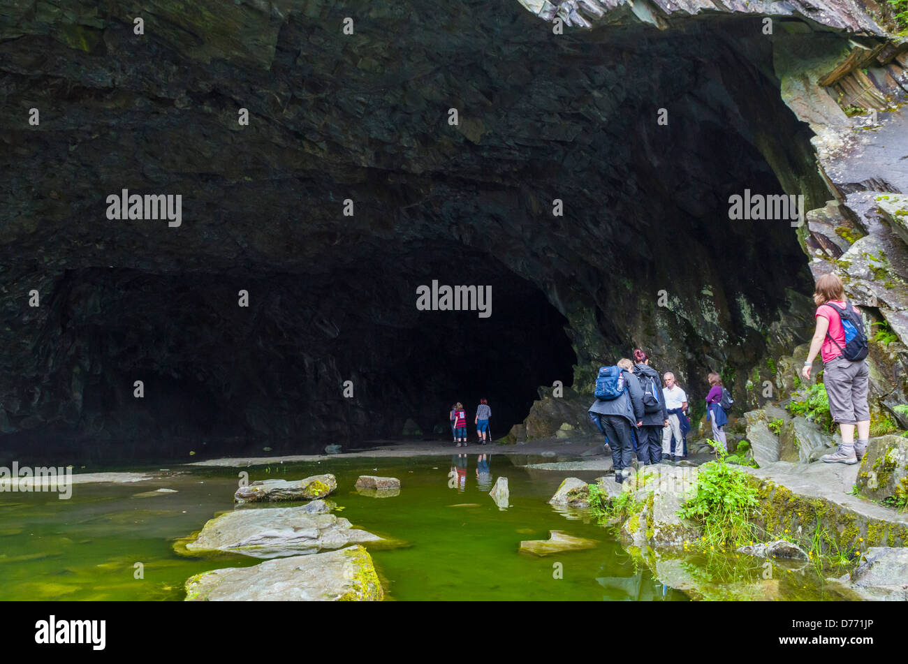 Persone nella bocca di una cava abbandonata grotta sul Loughrigg cadde nel distretto del lago, Cumbria, Inghilterra. Foto Stock