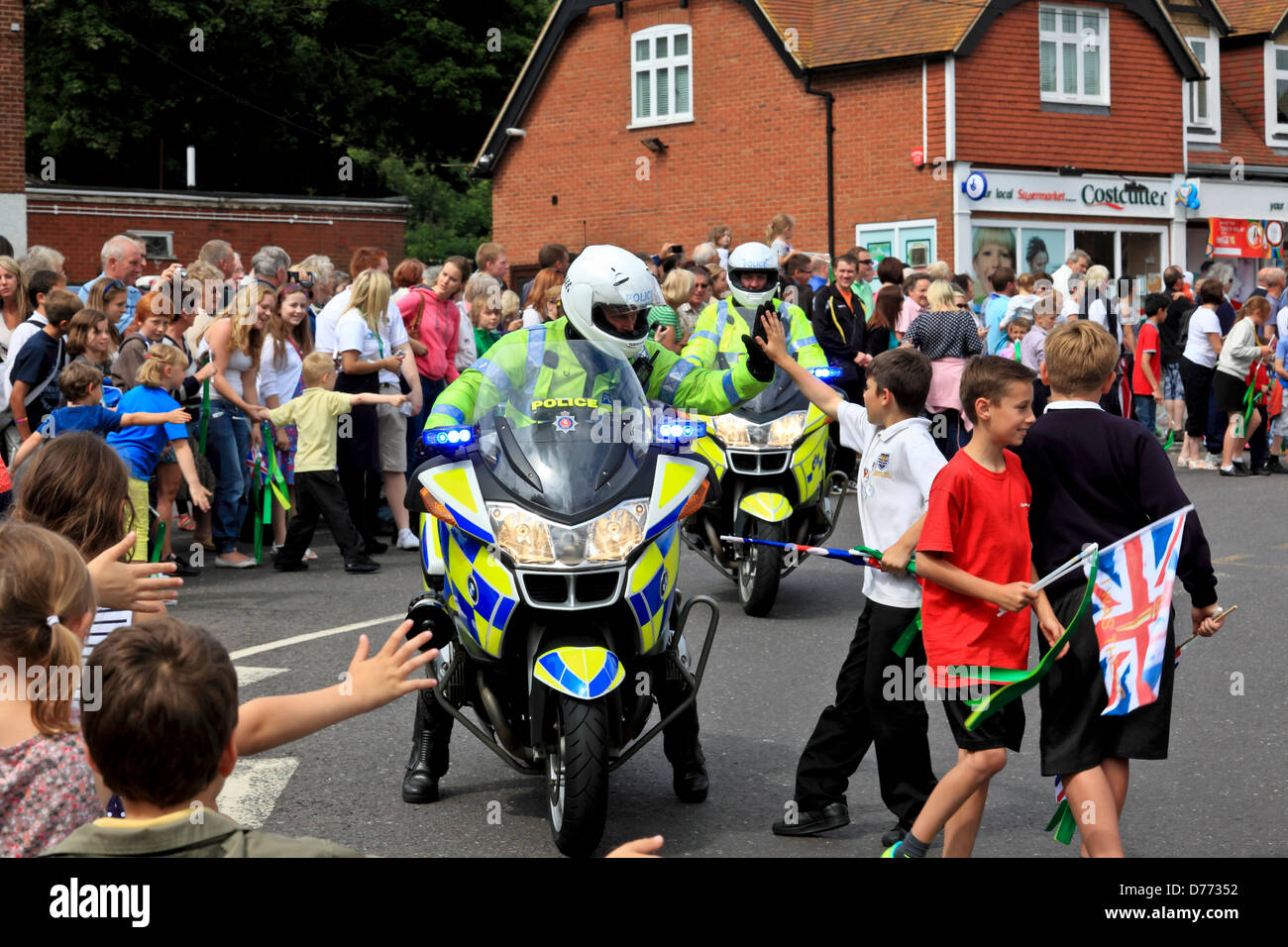 8690. Torcia Olimpica, battendo il cinque con la polizia Motociclista, Sturry, Kent, England, Regno Unito, Europa Foto Stock