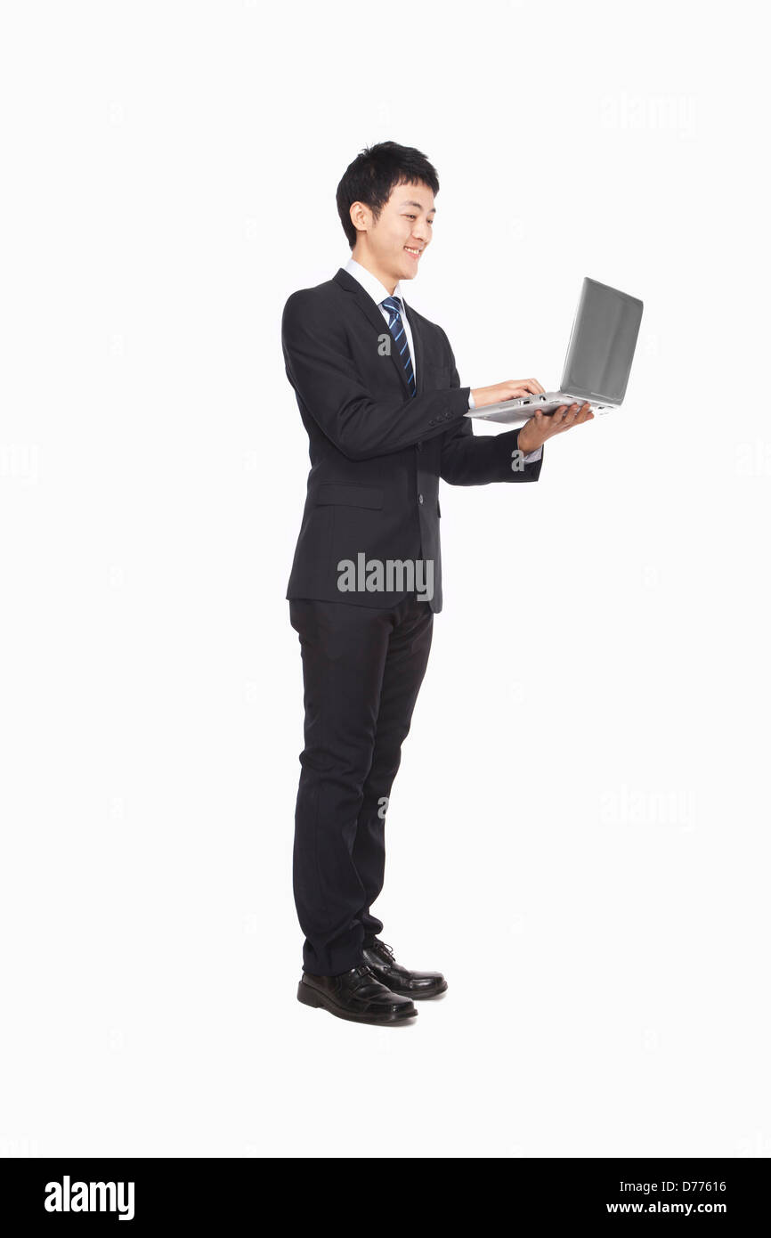 Uomo d affari con computer portatile mentre in piedi Foto Stock