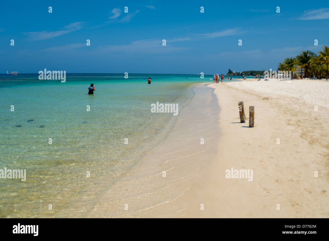 I turisti a languire su una soleggiata spiaggia tropicale sull'isola di Raotan, Honduras. Foto Stock