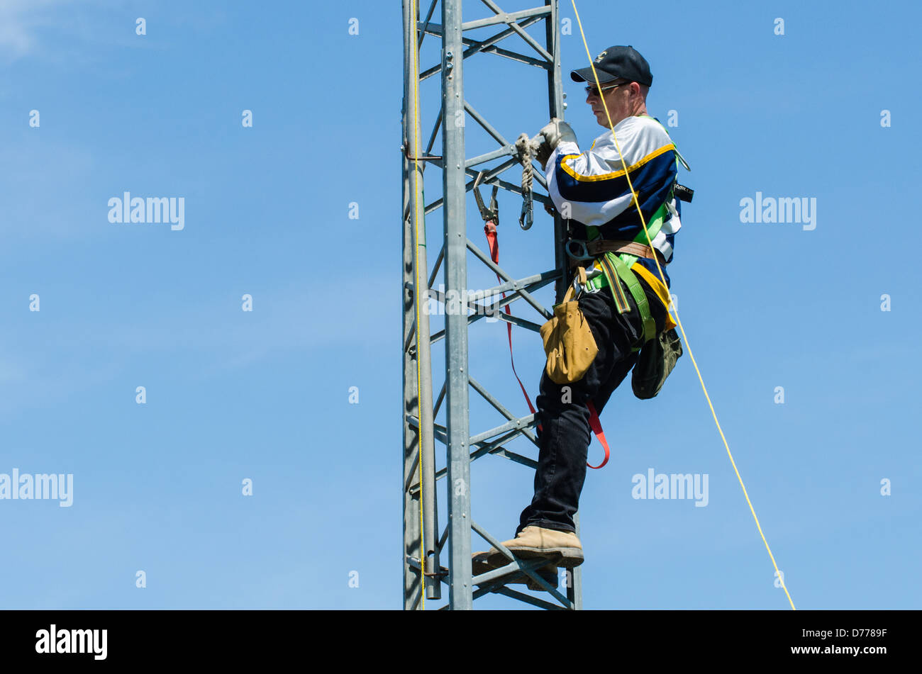 Uomo di arrampicata torre di antenna durante l'amateur radio l'installazione della torre. Foto Stock