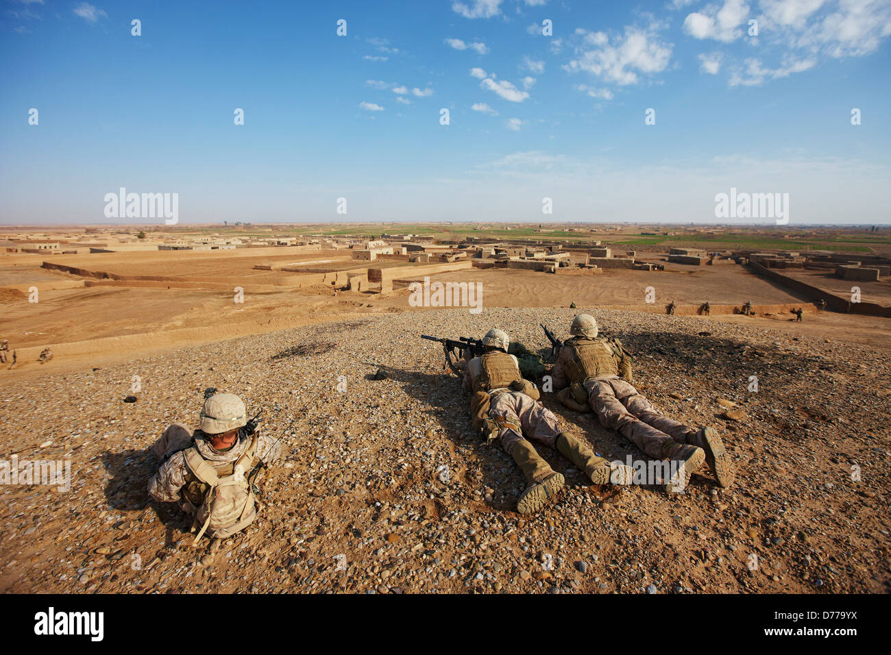 Stati Uniti Marine Corps designati ai tiratori si affacciano sulla città in Afghanistan la provincia di Helmand durante il combattimento il funzionamento Foto Stock