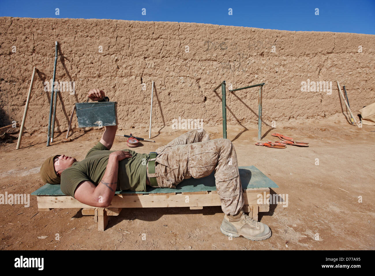 Un U.S. Marine funziona utilizzando le caselle di munizioni caricati pesi di sporco Foto Stock