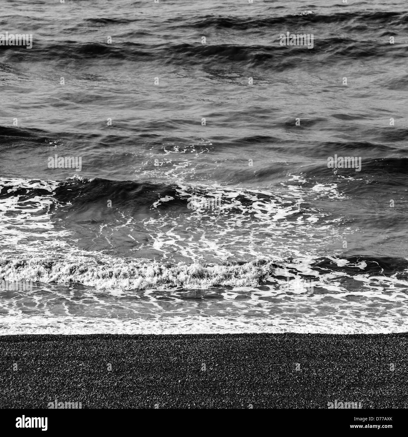 Le onde del mare e la spiaggia di ciottoli in bianco e nero Foto Stock