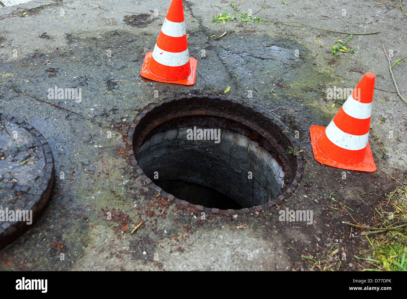 Aprire il coperchio del tombino con il cono Foto Stock