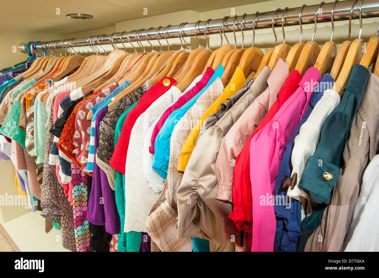 Varie multi-colore di capi di abbigliamento appesi su grucce e rampa in un  negozio Foto stock - Alamy