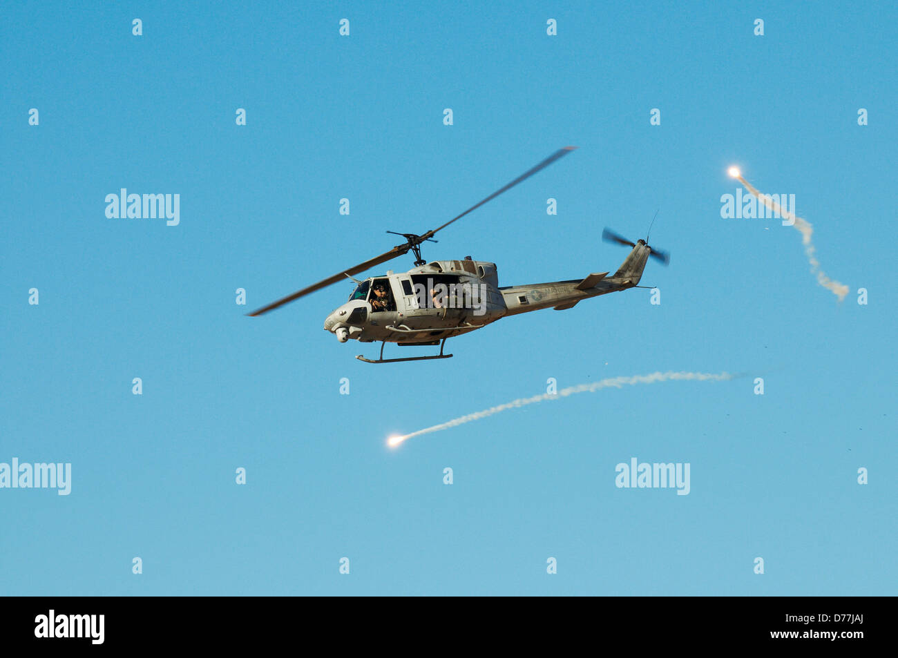 US Marine Corps UH-1N Iroquois Utility elicottero dotato di razzi mitragliatrici missione di attacco fà flares durante aria vicino Foto Stock