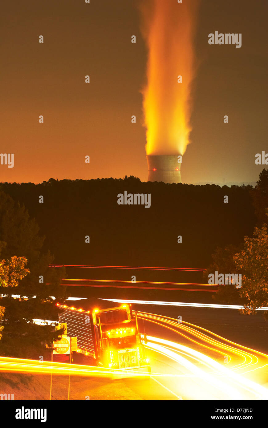 Vista notturna big rig carrello di appoggio sulla Interstate 40 Reattore nucleare Torre di raffreddamento a vapore di sfiato in background Arkansas Nuclear Foto Stock