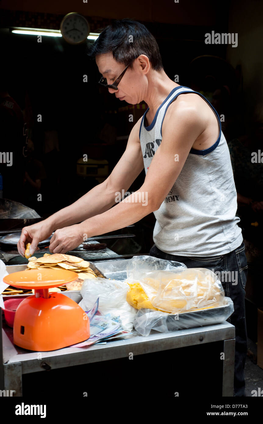 Un Cinese street food venditore al lavoro sulle strade di Macau, Cina Foto Stock