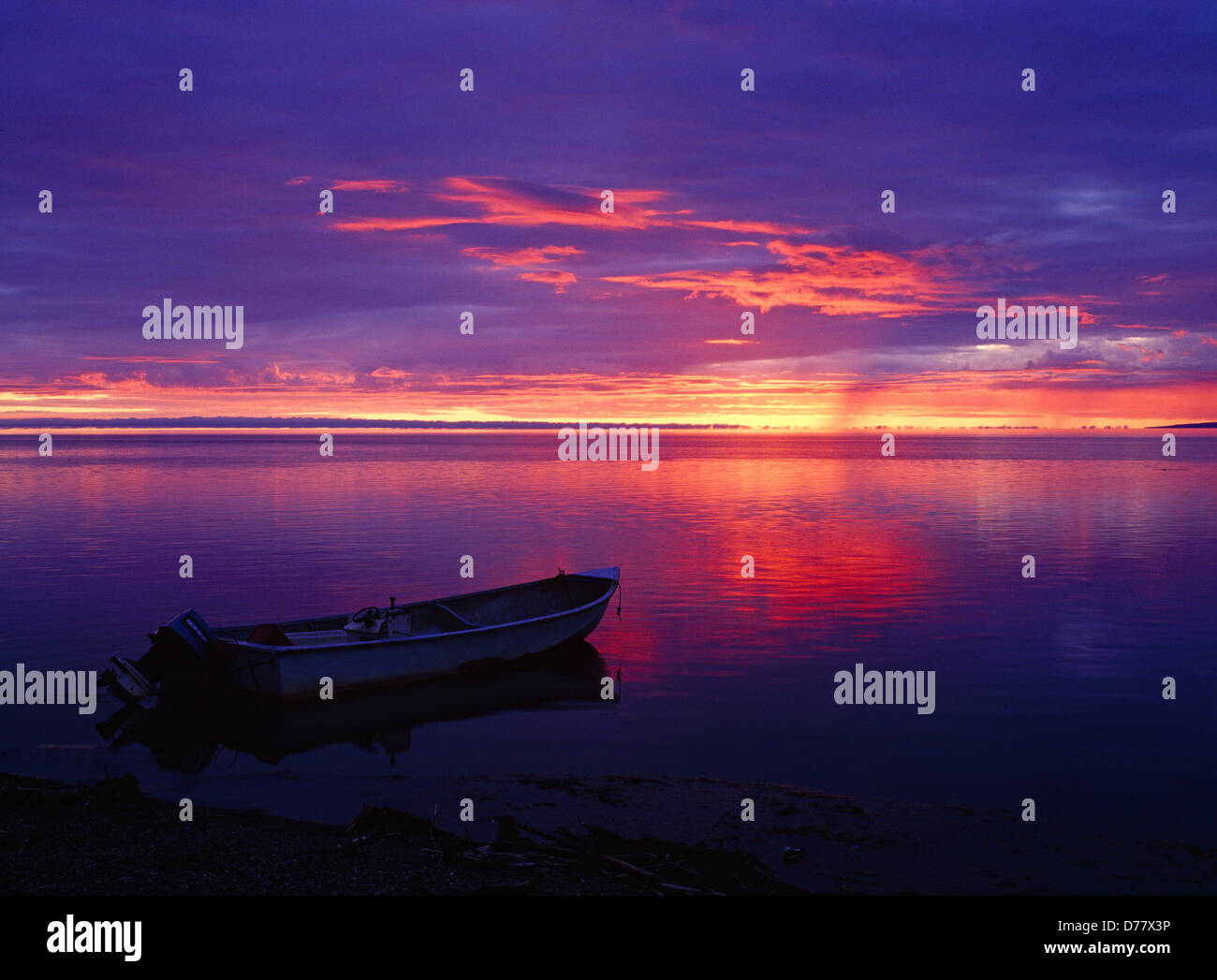 La luce del sole di mezzanotte scontornamento skiff su Kotzebue Sound Kotzebue Oceano Artico Alaska. Foto Stock