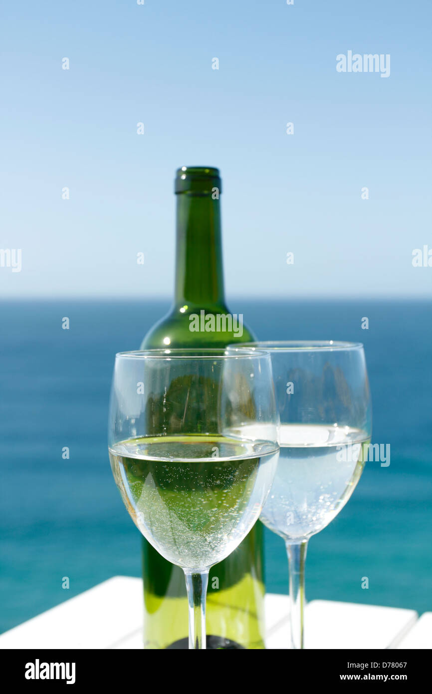 Bicchieri di vino su un tavolo bianco dall'oceano. Foto Stock