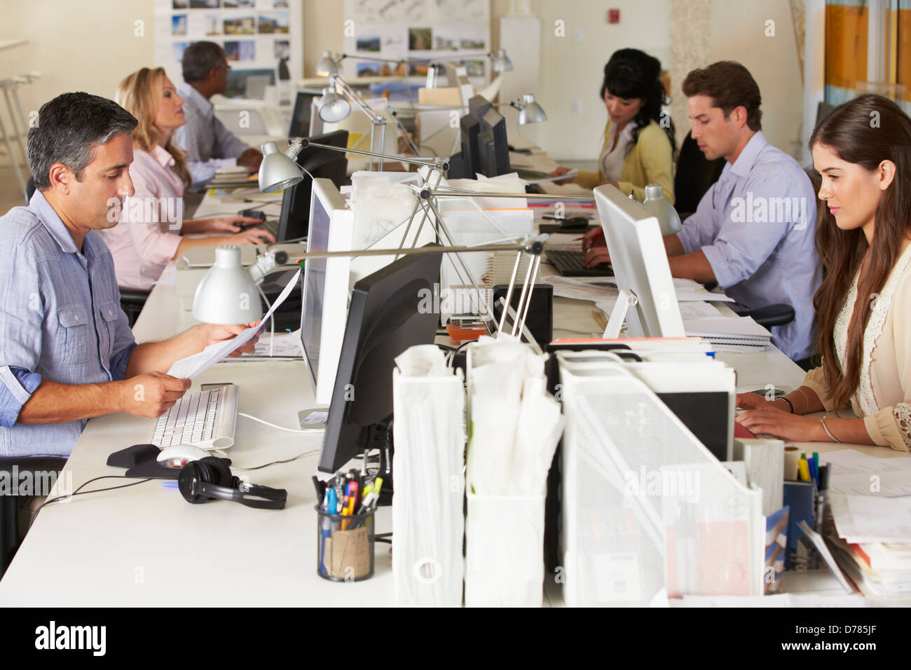 Team di lavoro alla scrivania in ufficio occupato Foto Stock