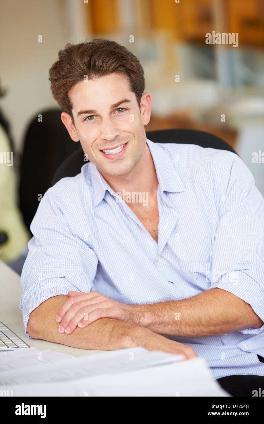 Uomo che lavora alla reception In occupato Ufficio creativo Foto Stock