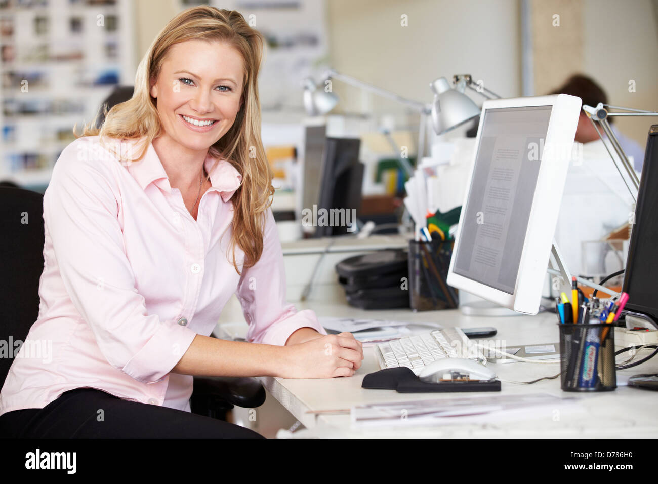 Donna che lavorano alla reception In occupato Ufficio creativo Foto Stock
