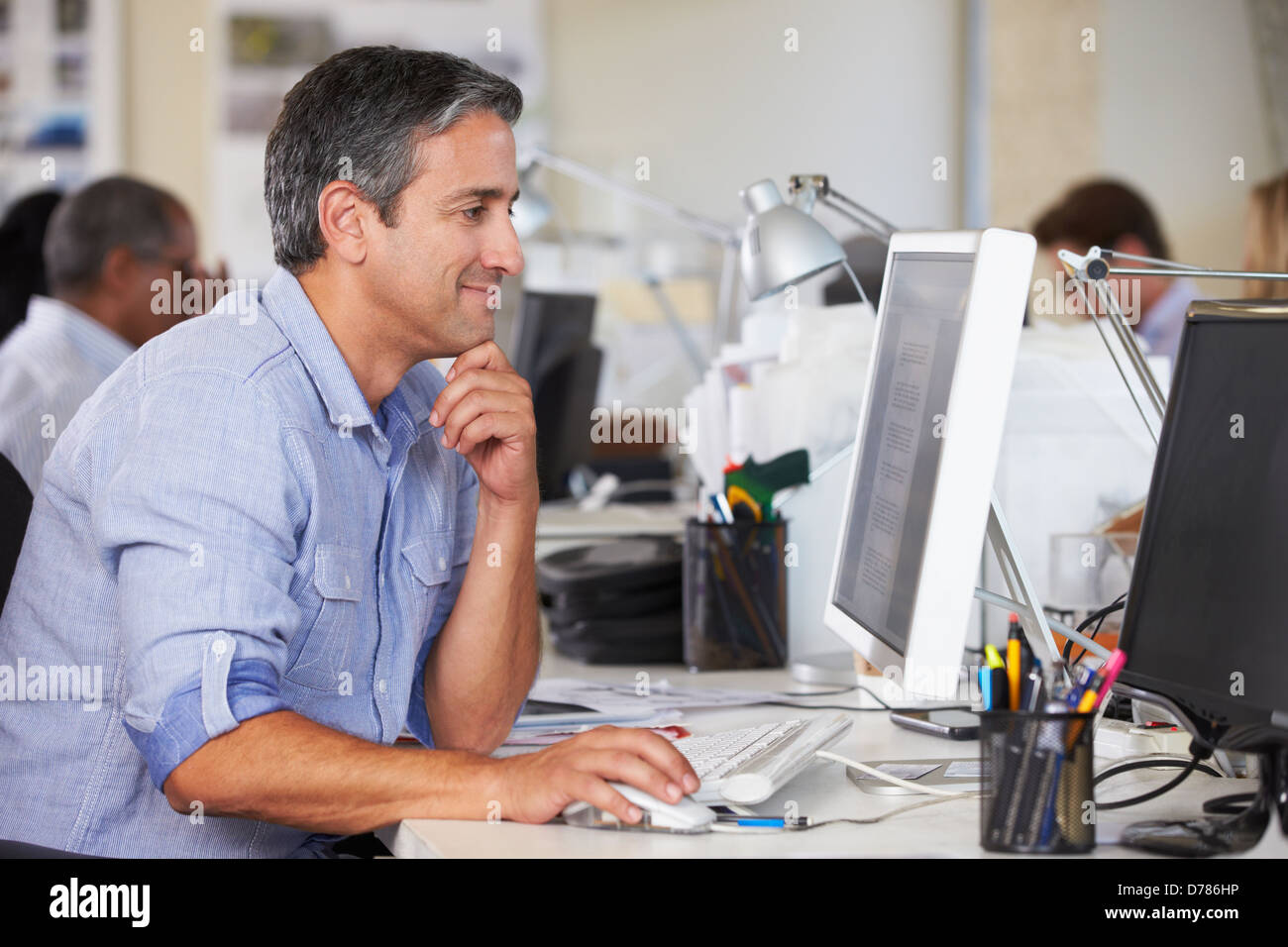 Uomo che lavora alla reception In occupato Ufficio creativo Foto Stock
