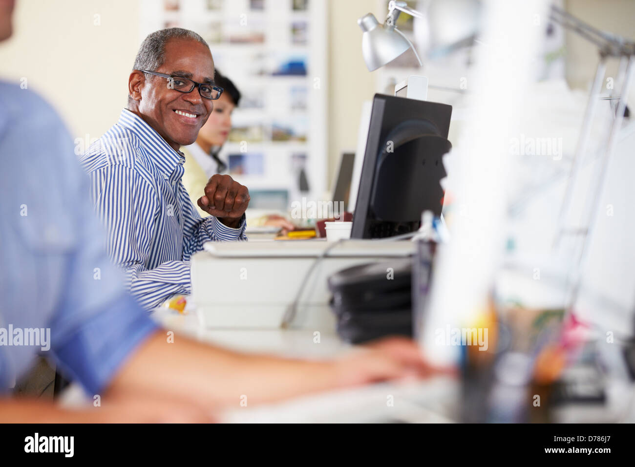 Uomo che lavora alla reception In occupato Ufficio creativo Foto Stock