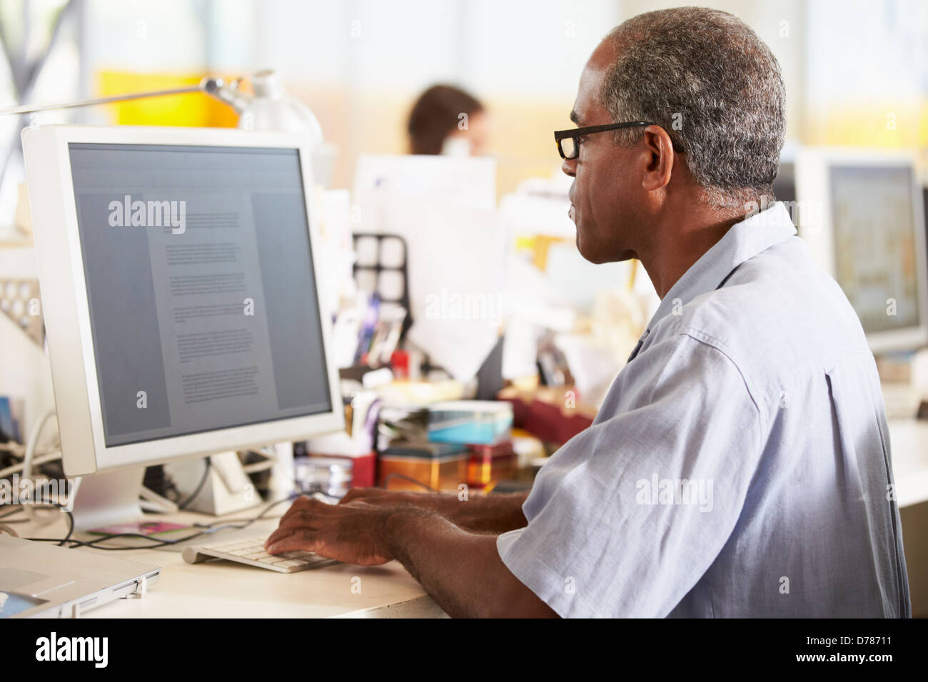 Uomo che lavora alla reception In occupato Ufficio creativo Foto Stock