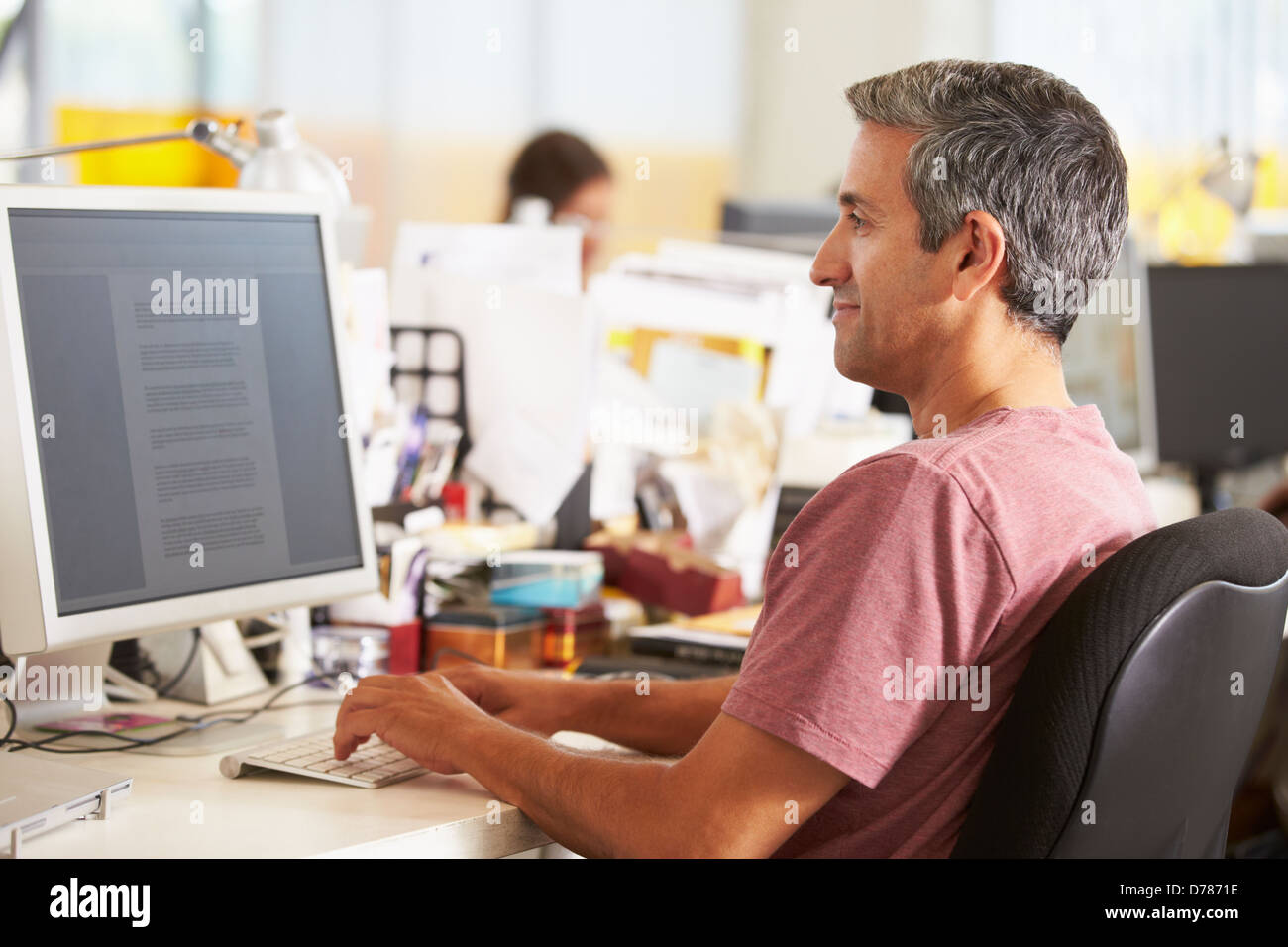 Uomo che lavora alla reception In occupato Ufficio creativo Foto Stock