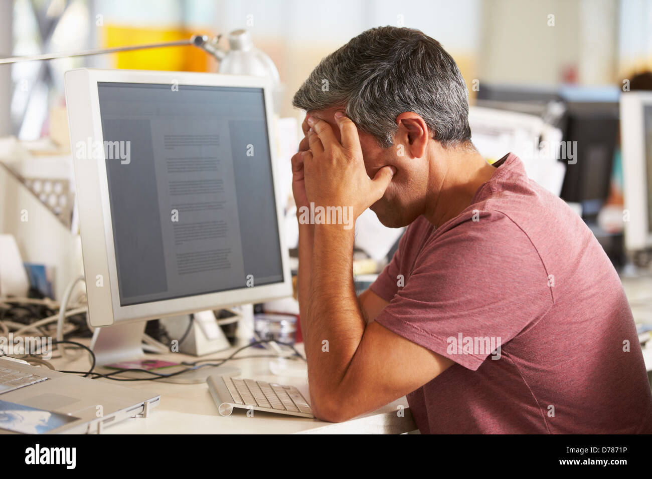 Sottolineato uomo che lavora alla reception In occupato Ufficio creativo Foto Stock